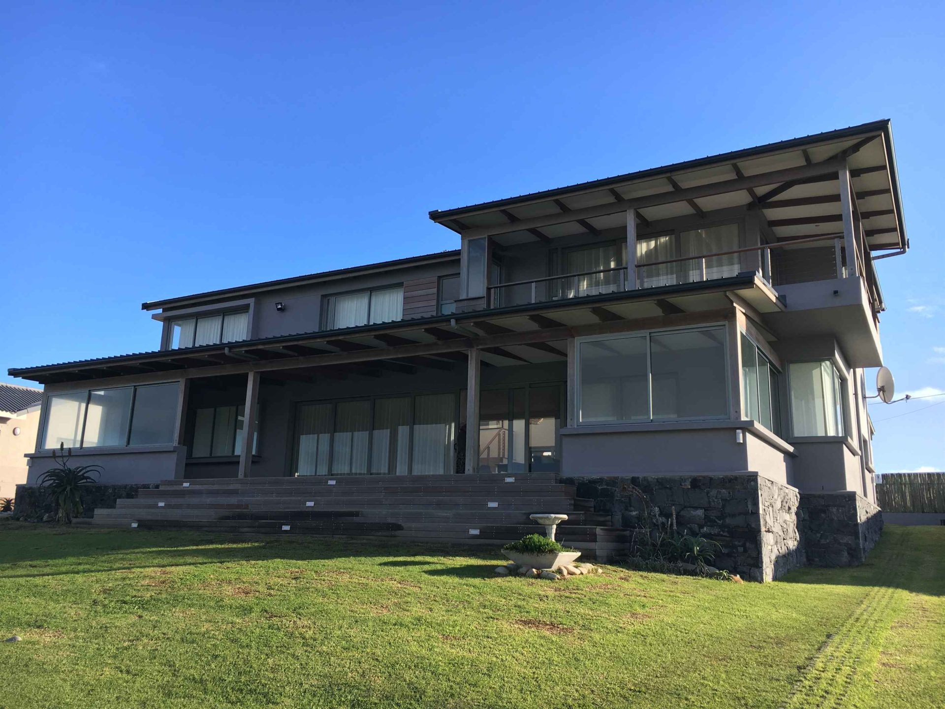 Sustainable family residence: spacious interior with elegant design, minimalist architectural details, and panoramic sea views, creating a tranquil ambiance in a modern beachfront retreat