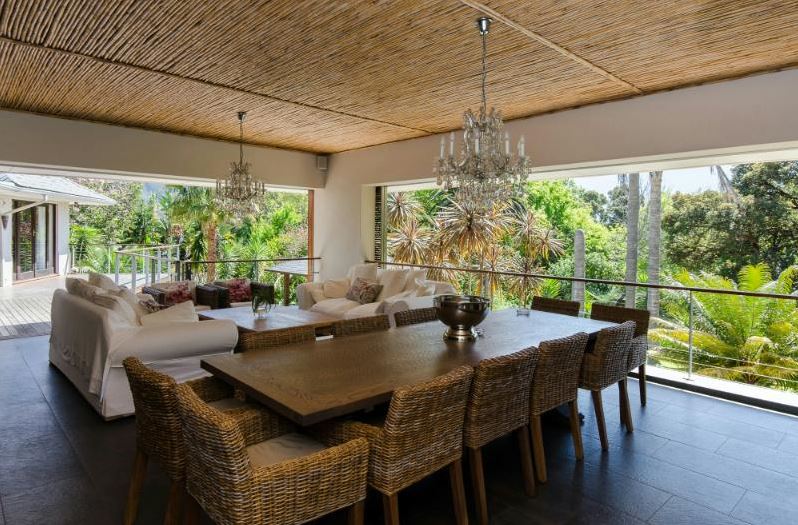 large lounge area on a balcony overlooking a lush forest
