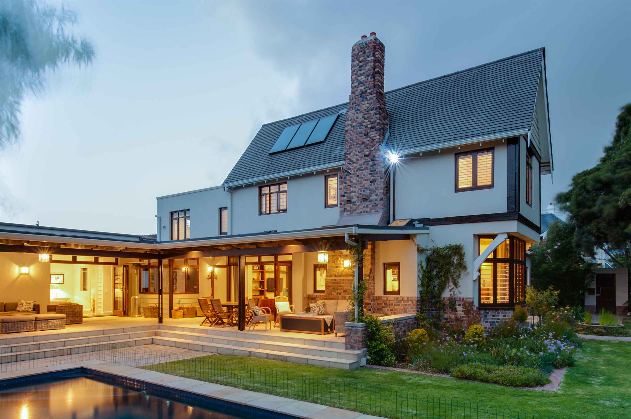 lassic yet modern house with a brick chimney and a pool